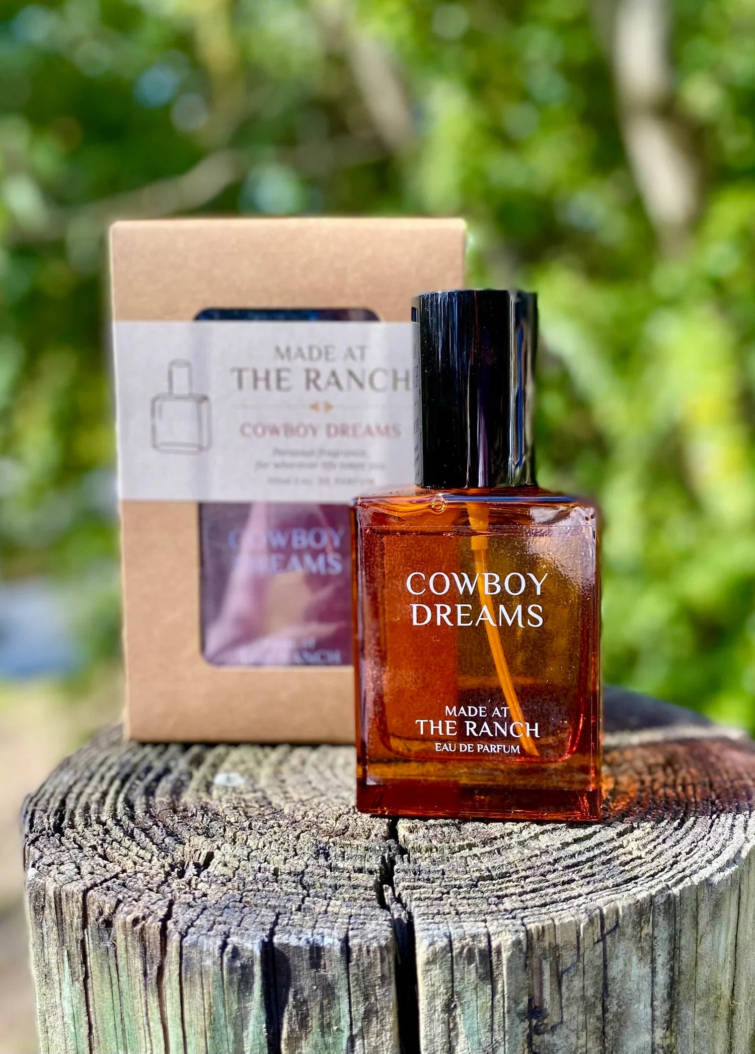 Cowboy Dreams perfume bottle and packaging on a wooden surface with a natural background